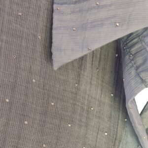 Close-up of bead embellishments on blue textured shirt