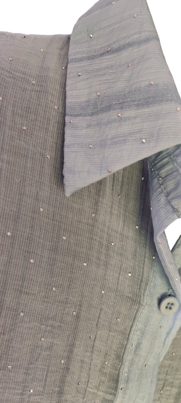 Close-up of bead embellishments on blue textured shirt