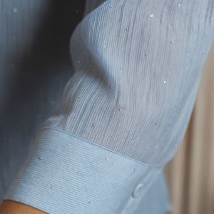 Close-up of bead embellishments on blue textured shirt