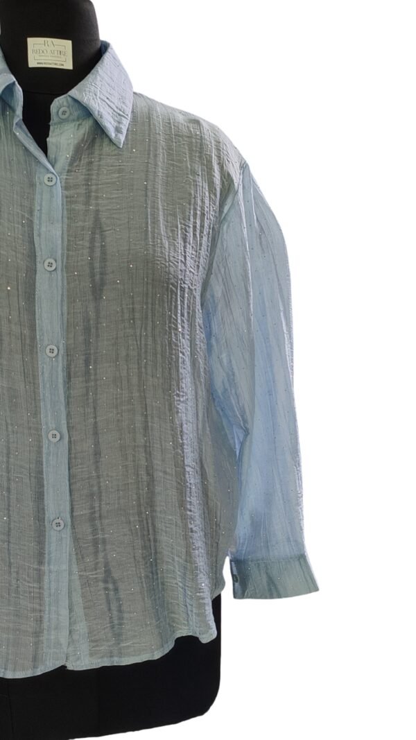 Close-up of bead embellishments on blue textured shirt
