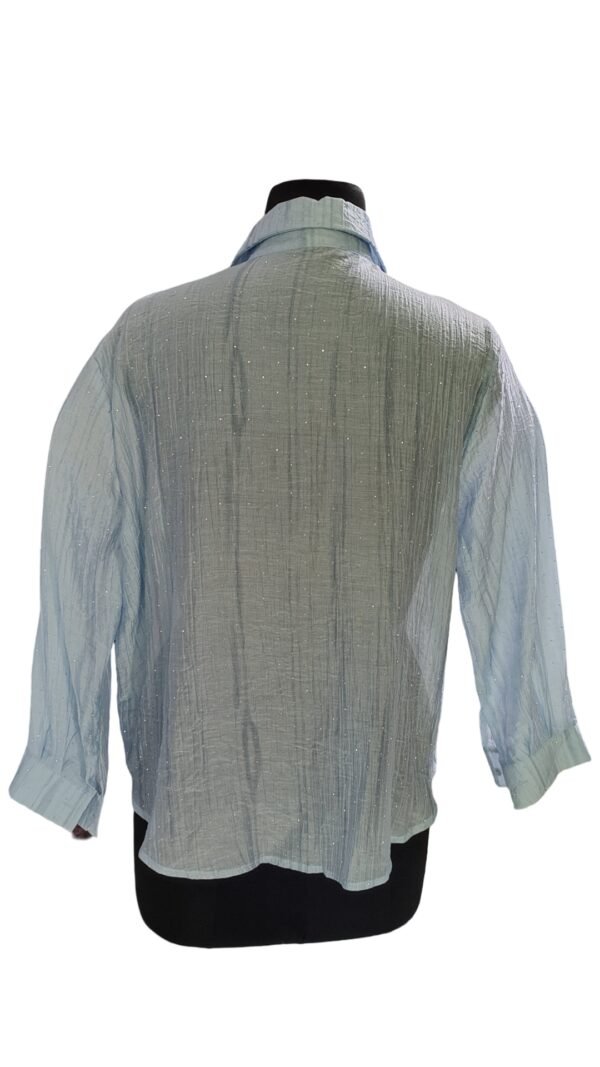 Close-up of bead embellishments on blue textured shirt