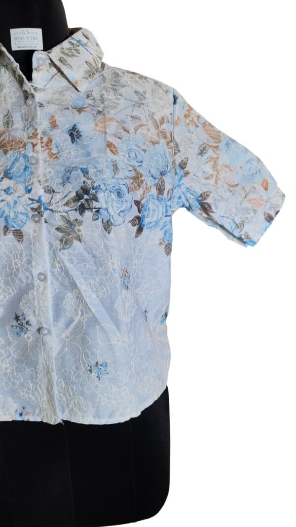 Woman wearing embroidered floral summer shirt with blue jeans