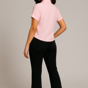 Woman in blush pink short-sleeve shirt with floral embroidery paired with black flared pants and white sneakers