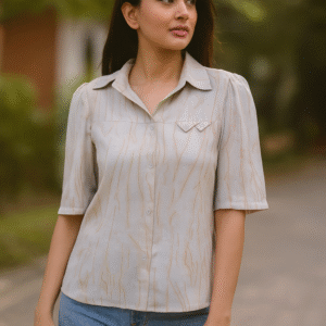 Woman wearing a beige textured short-sleeve shirt with collar and light denim jeans outdoors