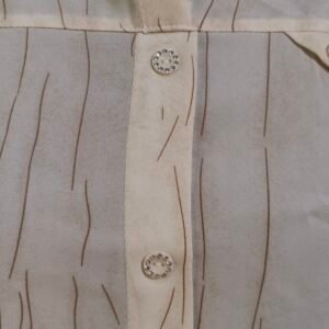 Close-up of textured beige button-up shirt with subtle stripe detailing
