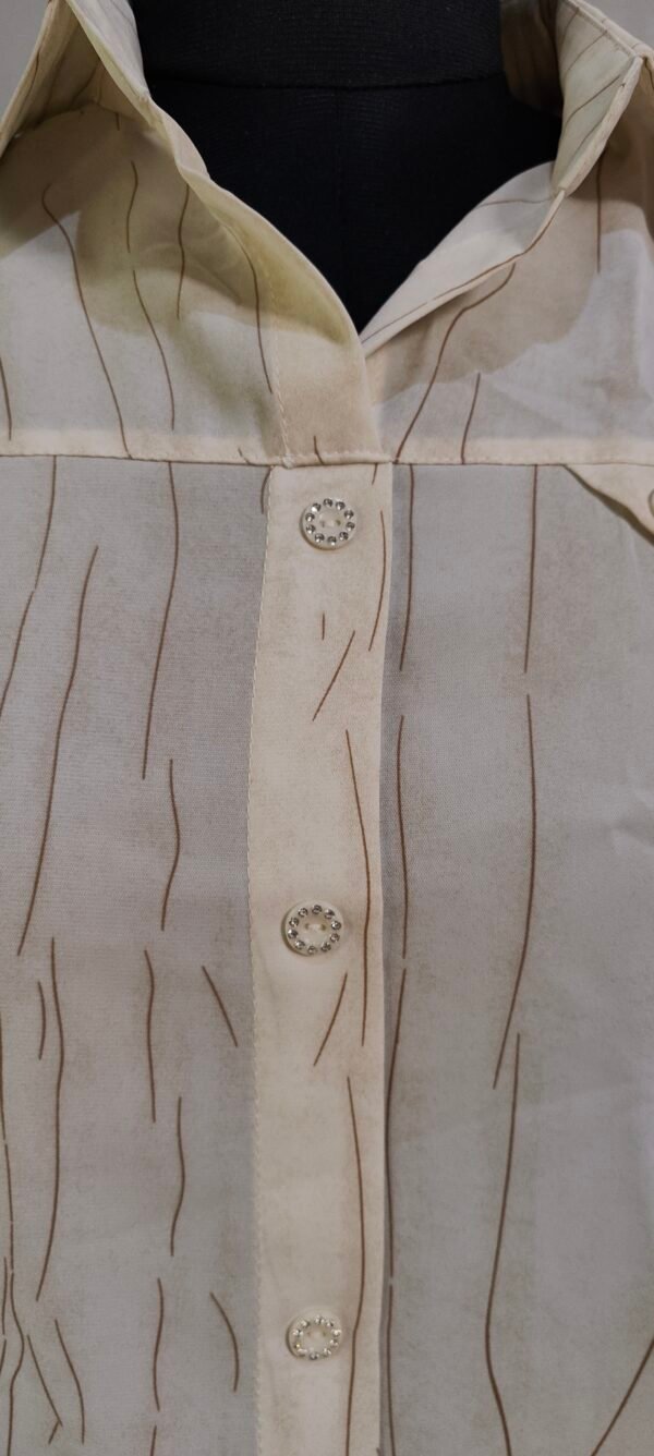 Close-up of textured beige button-up shirt with subtle stripe detailing