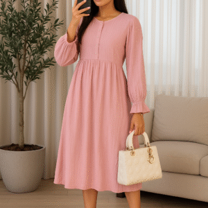 Woman in dusty rose pink midi dress with gathered waist and balloon sleeves holding white bag