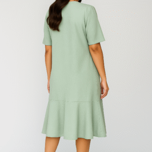 Woman wearing mint-green midi dress with flowy bottom and pearl necklace