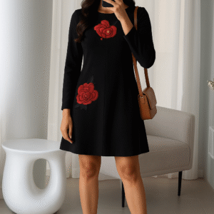 Woman wearing black A-line dress with red floral embroidery and black-red heels