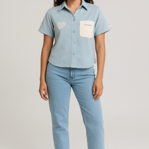Woman in light blue short-sleeve shirt with heart detail and jeans