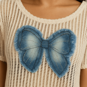 Model wearing net crop top with denim bow paired with high-waist jeans and sneakers