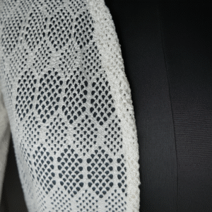 model wearing white crochet shrug with black outfit
