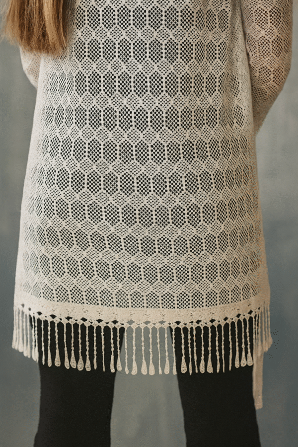 model wearing white crochet shrug with black outfit