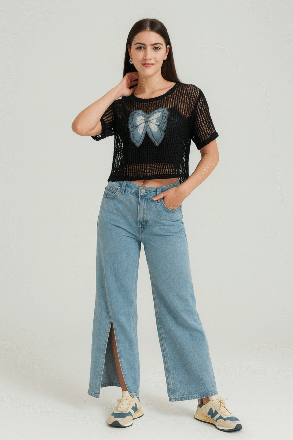 Model wearing black net top with spaghetti inner paired with blue jeans