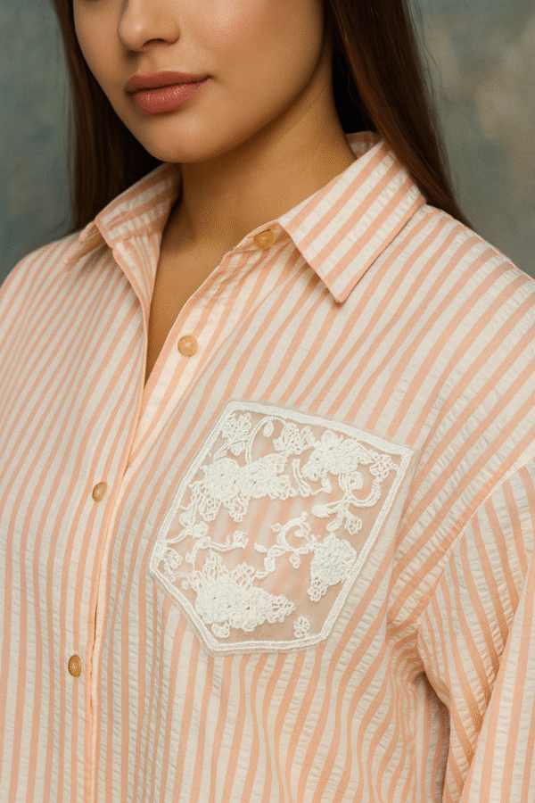 Close-up of lace-trimmed cuff on striped women’s shirt